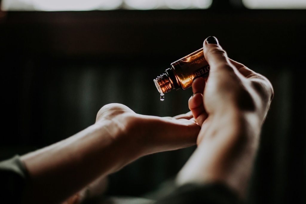 person holding amber glass bottle for a self massage